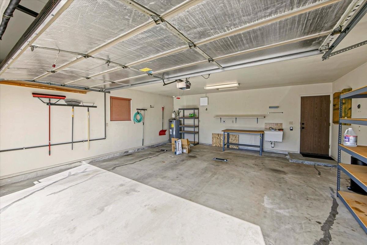 Attached two-car garage with a workbench area along the back wall at 4184 N Kearny Dr