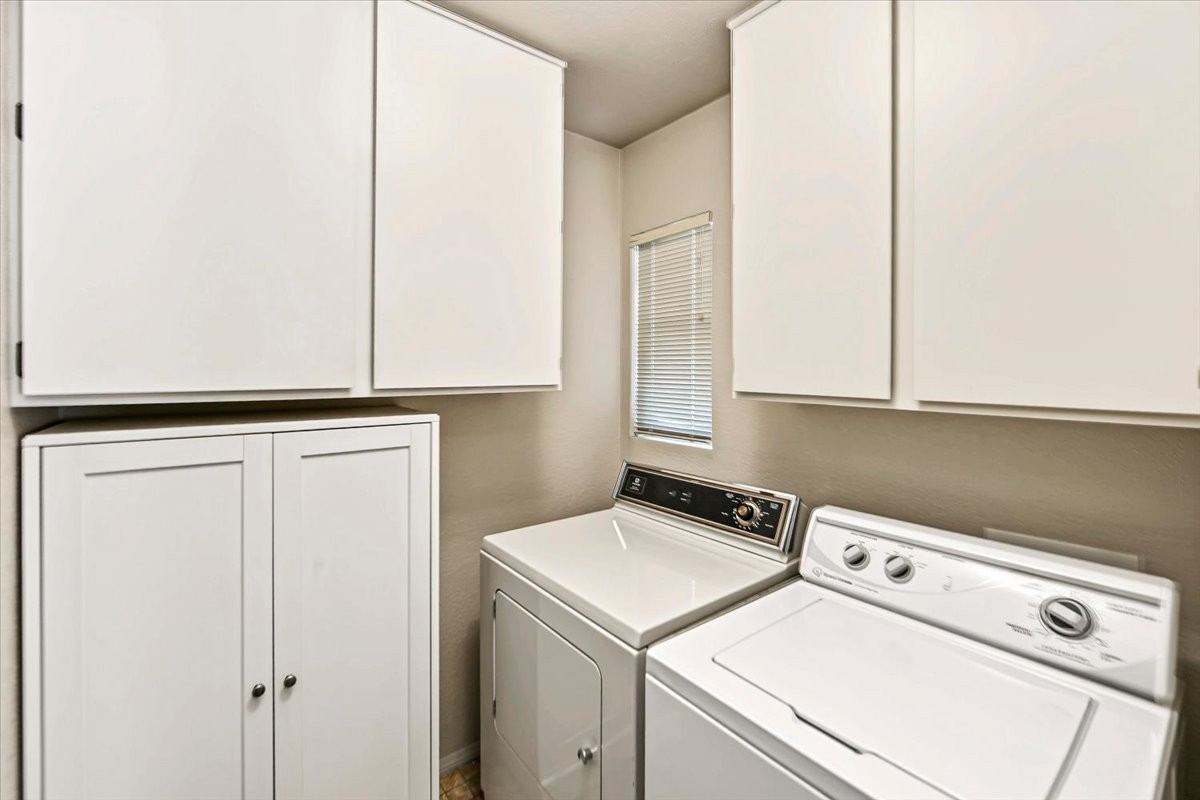 Laundry area with washer, dryer and white built-in cabinets at 4184 N Kearny Dr