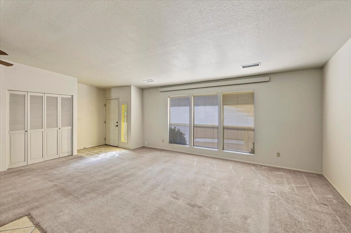 Living room with large windows and louvered closet doors at 4184 N Kearny Dr