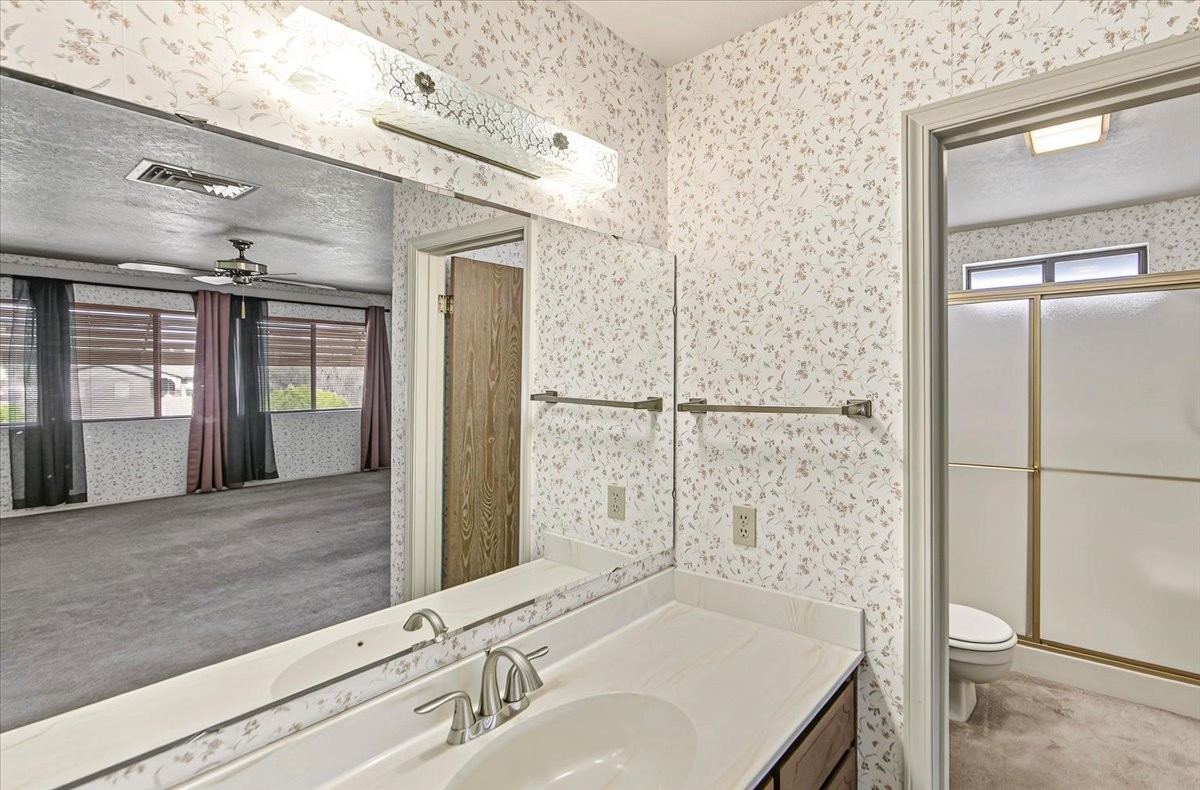 Primary bathroom with floral wallpaper and a vanity at 4184 N Kearny Dr