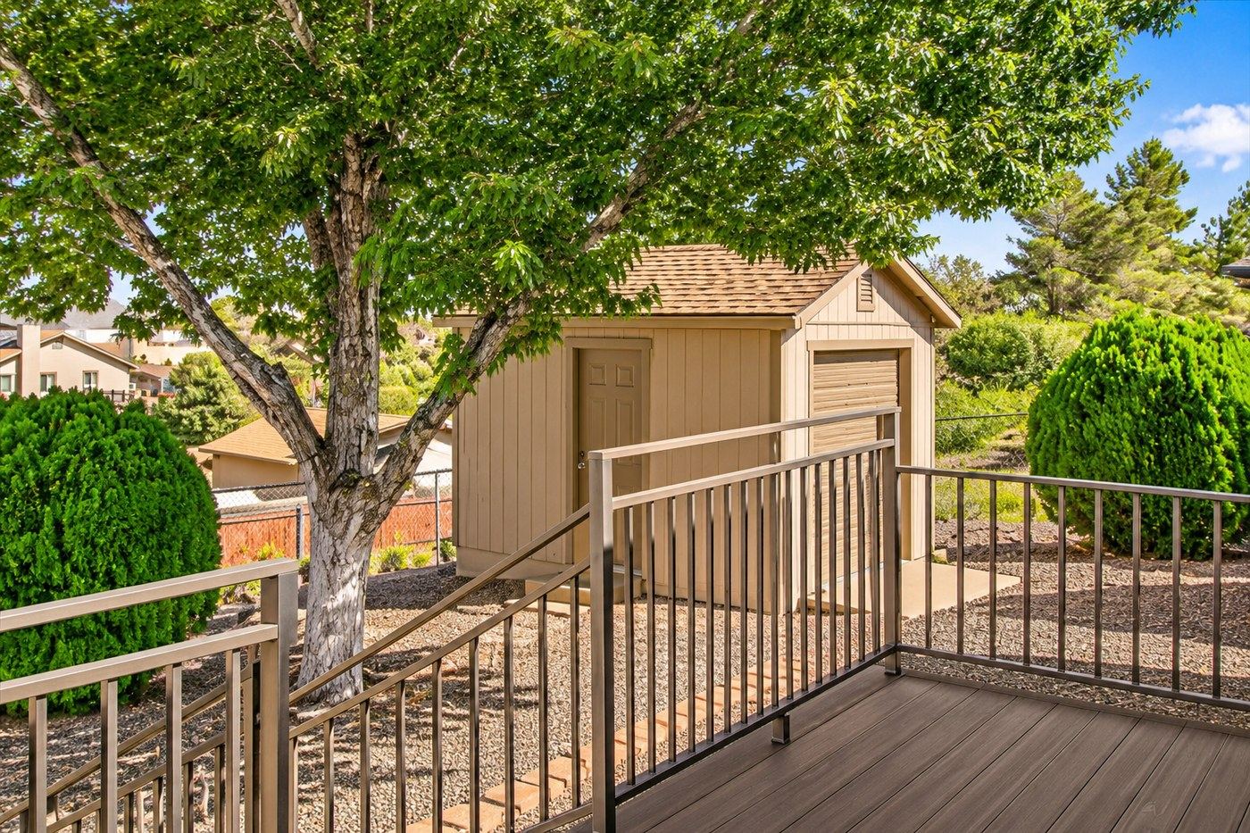 Digitally enhanced image of the detached workshop with its roll-up door closed, seen from the rear deck at 4184 N Kearny Dr