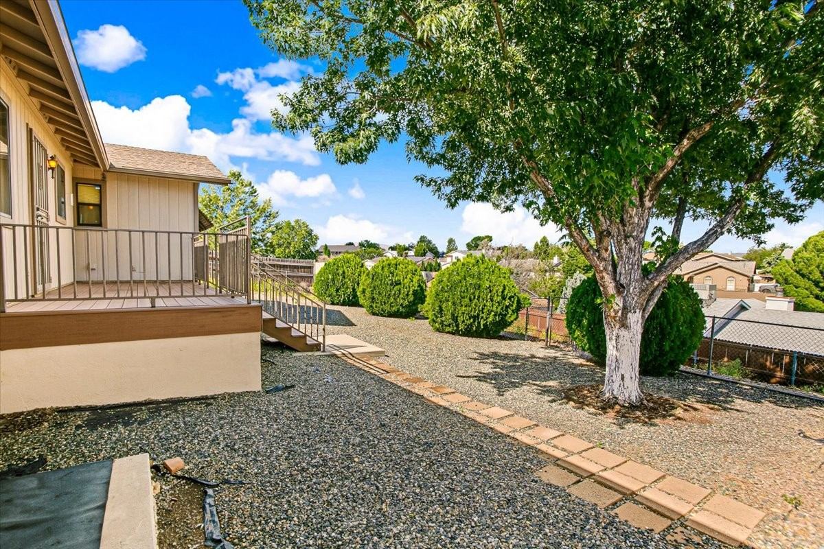 Low-maintenance gravel yard with a mature tree behind the rear deck at 4184 N Kearny Dr