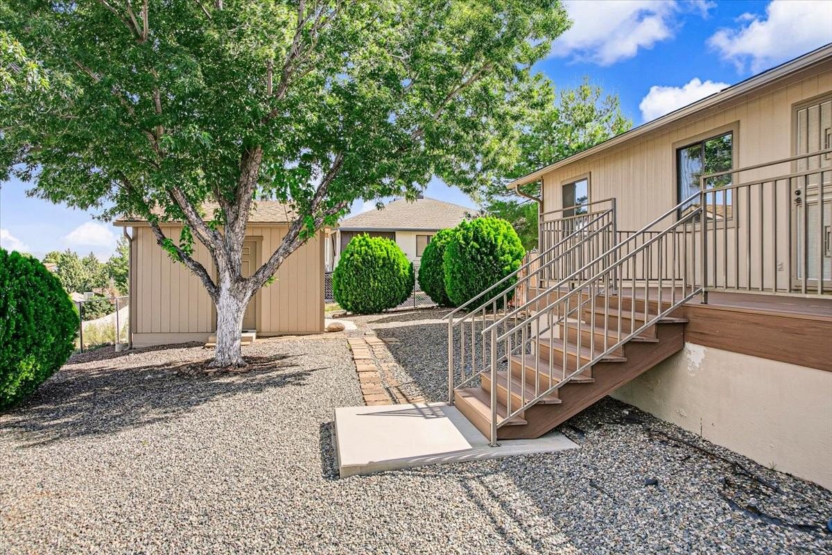 Rear deck stairs, mature tree and the detached workshop in the yard at 4184 N Kearny Dr